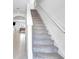 Modern staircase with gray carpeting and white railings at 17033 Oval Rum Dr, Wimauma, FL 33598