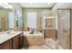 Spa-like bathroom with a soaking tub, walk-in shower, and updated vanity at 18442 New London Ave, Land O Lakes, FL 34638