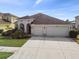 Three-car garage home with manicured landscaping at 18442 New London Ave, Land O Lakes, FL 34638