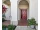 Inviting front entrance with red door and arched entryway at 18442 New London Ave, Land O Lakes, FL 34638