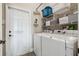 Bright laundry room with washer, dryer, and shelving at 18442 New London Ave, Land O Lakes, FL 34638