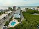 Aerial view showing condo complex with pool, ocean, and tropical foliage at 19727 Gulf Blvd # C-1, Indian Shores, FL 33785