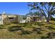 Home's backyard with large tree and grassy area at 204 Sky Loch W Dr, Dunedin, FL 34698