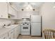 Small galley kitchen with white appliances and cabinetry at 204 Sky Loch W Dr, Dunedin, FL 34698