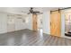 Living room with gray vinyl flooring and barn doors at 281 Grove Rd, Venice, FL 34293