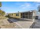 Home's backyard with patio, screened in porch, and freshly painted yellow exterior at 3235 Merita Dr, Holiday, FL 34691