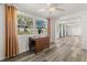 Bright eat in dining area adjacent to living space featuring modern gray laminate flooring and large windows at 3235 Merita Dr, Holiday, FL 34691