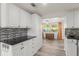 Bright modern kitchen featuring white cabinetry and black granite countertops with an eat in dining area at 3235 Merita Dr, Holiday, FL 34691