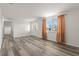 Bright living room featuring new wood floors, fresh white paint and a large window for natural light at 3235 Merita Dr, Holiday, FL 34691