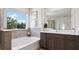 Spa-like bathroom with soaking tub, vanity, and large window at 32465 Osprey Peak Way, San Antonio, FL 33576