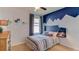 Bedroom with mountain mural, wood headboard, and navy accents at 32763 Osprey Peak Way, San Antonio, FL 33576