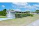 Side view of a white mobile home with carport and hedges at 37350 Tropical Dr, Zephyrhills, FL 33541