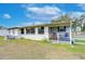 White mobile home with covered porch and rocking chairs at 37350 Tropical Dr, Zephyrhills, FL 33541