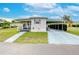 Front view of a white mobile home with carport and landscaping at 37350 Tropical Dr, Zephyrhills, FL 33541