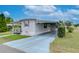 White single-wide manufactured home with carport and covered porch at 37350 Tropical Dr, Zephyrhills, FL 33541