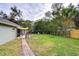 Large backyard with spacious grassy area, wooden fence, and patio at 38902 Inez Ave, Zephyrhills, FL 33542