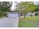 House exterior boasts a white garage door and well-manicured lawn at 38902 Inez Ave, Zephyrhills, FL 33542