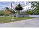 Gray house with American flag, palm tree, and gravel driveway at 38902 Inez Ave, Zephyrhills, FL 33542