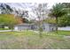 Gray house with stone pathway, landscaping, and a detached garage at 38902 Inez Ave, Zephyrhills, FL 33542