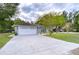 Gray house with white garage door, landscaping, and a long driveway at 38902 Inez Ave, Zephyrhills, FL 33542