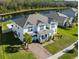 Two-story house with gray roof, paver driveway, and landscaped yard, near a lake at 3898 Barbour Trail, Odessa, FL 33556