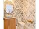 Stylish powder room with a unique patterned wallpaper and gold accents at 3898 Barbour Trail, Odessa, FL 33556