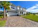 Two-story house with white siding, gray roof, and paver driveway at 3898 Barbour Trail, Odessa, FL 33556