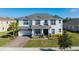 Two-story home with gray roof, white siding, and landscaping at 3898 Barbour Trail, Odessa, FL 33556