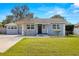 Charming Bungalow style home with gray exterior, landscaped lawn, and driveway at 4424 W Bay Villa Ave, Tampa, FL 33611