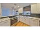 Modern kitchen with white cabinets, quartz counters, and gray tile backsplash at 4619 W Bay Villa Ave, Tampa, FL 33611