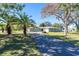 Ranch-style home with palm trees and a long driveway at 5105 W Country Club Dr, Sarasota, FL 34243