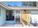 Modern house entrance with wood accent wall and welcome mat at 5105 W Country Club Dr, Sarasota, FL 34243