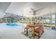 Poolside patio with wooden table and bench seating at 5105 W Country Club Dr, Sarasota, FL 34243