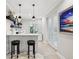 Modern wet bar with white cabinetry, floating shelves, and barstools at 595 5Th Ne Ave, St Petersburg, FL 33701