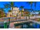 Night view of a waterfront home with a private dock and lights at 644 Boca Ciega Isle Dr, St Pete Beach, FL 33706