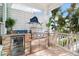 Well-equipped outdoor kitchen with grill, refrigerator, and stone accents at 644 Boca Ciega Isle Dr, St Pete Beach, FL 33706