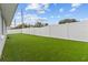 Large backyard with artificial turf and a white fence at 6950 113Th St, Seminole, FL 33772