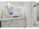 Double vanity bathroom with white cabinets and brushed nickel fixtures at 701 Poinsettia Rd # 302, Belleair, FL 33756