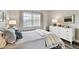 Well-lit bedroom, featuring a dresser and comfortable bed at 701 Poinsettia Rd # 302, Belleair, FL 33756