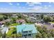 Aerial view of a teal house and its surroundings, showing a canal and other homes at 711 Eagle Ln, Apollo Beach, FL 33572