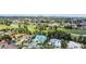 Aerial view of a teal house with a golf course in the background at 711 Eagle Ln, Apollo Beach, FL 33572