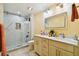 Bathroom with double vanity, large mirror, and glass shower at 711 Eagle Ln, Apollo Beach, FL 33572