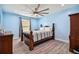 Bedroom with light blue walls, wooden bed frame, and ceiling fan at 711 Eagle Ln, Apollo Beach, FL 33572