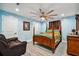 Bedroom with light blue walls, wooden bed frame, and ceiling fan at 711 Eagle Ln, Apollo Beach, FL 33572