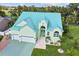 Exterior view of a teal house with a three-car garage and lush landscaping at 711 Eagle Ln, Apollo Beach, FL 33572