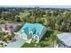 Exterior view of a teal house with a three-car garage and lush landscaping at 711 Eagle Ln, Apollo Beach, FL 33572