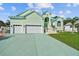 Beautiful light green house with a three-car garage and lush lawn at 711 Eagle Ln, Apollo Beach, FL 33572