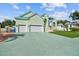 Spacious light green house with a three-car garage, boat, and well-maintained lawn at 711 Eagle Ln, Apollo Beach, FL 33572