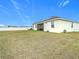 Large backyard with spacious grassy area and home with solar panels at 7395 Steer Blade Dr, Zephyrhills, FL 33541