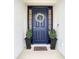 Inviting front door entrance with a decorative wreath and potted plants at 7395 Steer Blade Dr, Zephyrhills, FL 33541